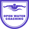 A purple and white logo depicts a swimmer with outstretched arms above wavy lines. Beneath the swimmer, the text reads "Open Water Coaching" inside a shield-shaped border.